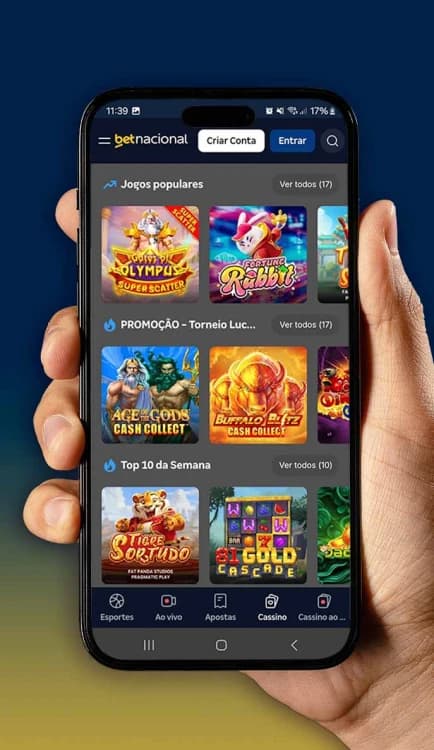 Celular mostrando a interface do site BetNacional com jogos populares, promoções e top 10 da semana, segurado por uma mão sobre fundo azul.